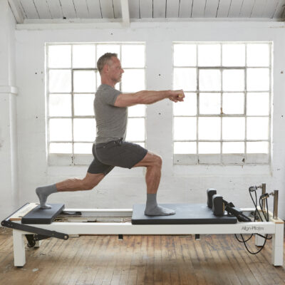 Man using pilates reformer with platform extender